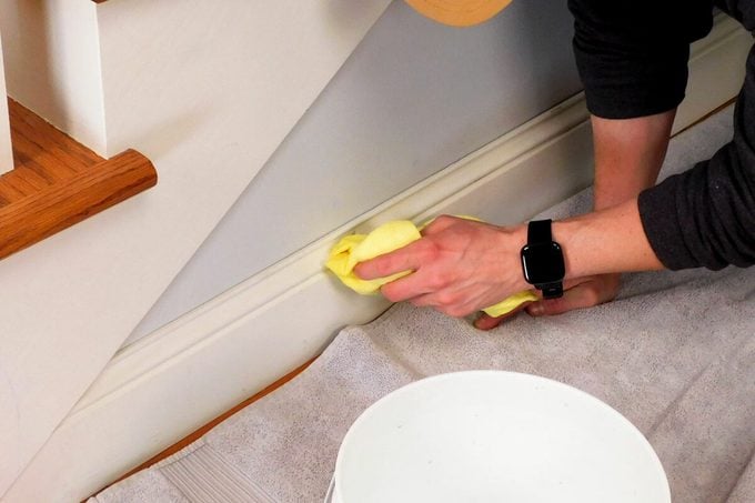 professional cleaner deep cleaning baseboards and hard to reach areas in a home
