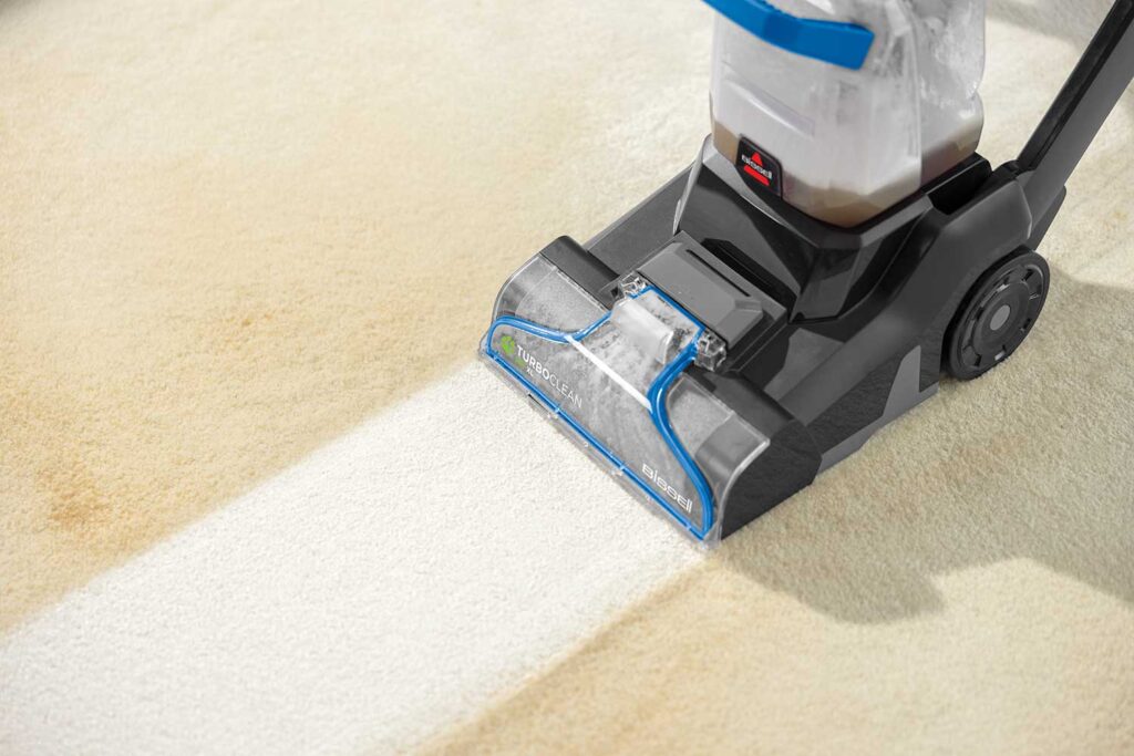 person vacuuming carpet to remove pollen and dust during spring cleaning