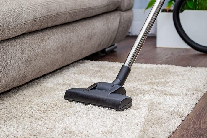 professional cleaner vacuuming living room in a busy North Jersey home