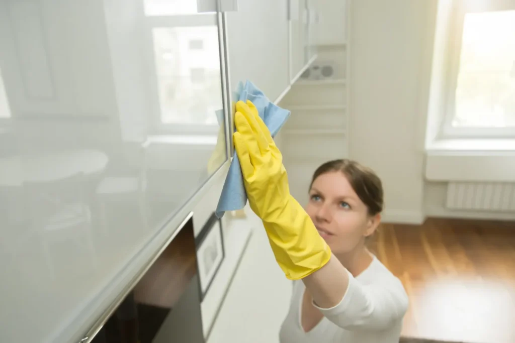 professional cleaner sanitizing kitchen cabinets before moving into a New Jersey home
