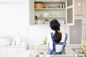 homeowner organizing and cleaning a modern apartment kitchen in New Jersey